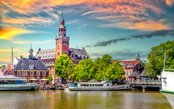 Hafen mit Booten und historischer Architektur bei Sonnenuntergang.