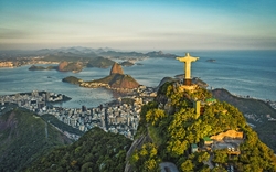 Luftaufnahme der Christusstatue in Rio de Janeiro bei Sonnenuntergang, mit Küstenblick.